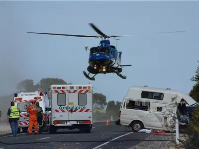 helicopter flying above ambulance car crash scene