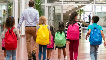 children in different colored backpacks walking