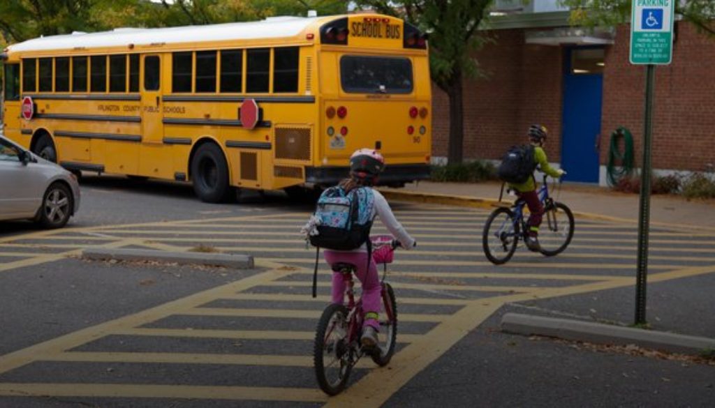 kids on crosswalk with school bus in background