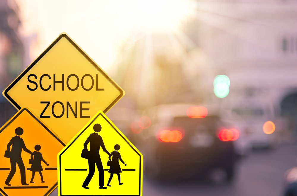 school crosswalk signs with traffic in background