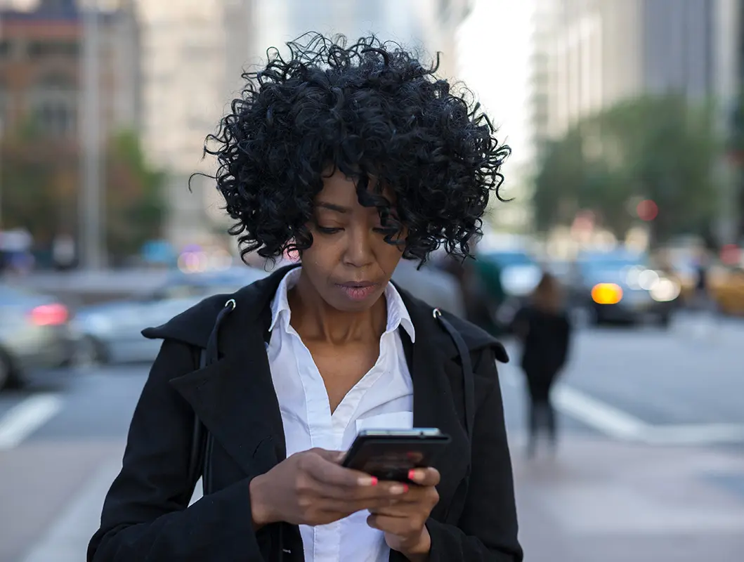 Business woman in New York City texting on cell phone