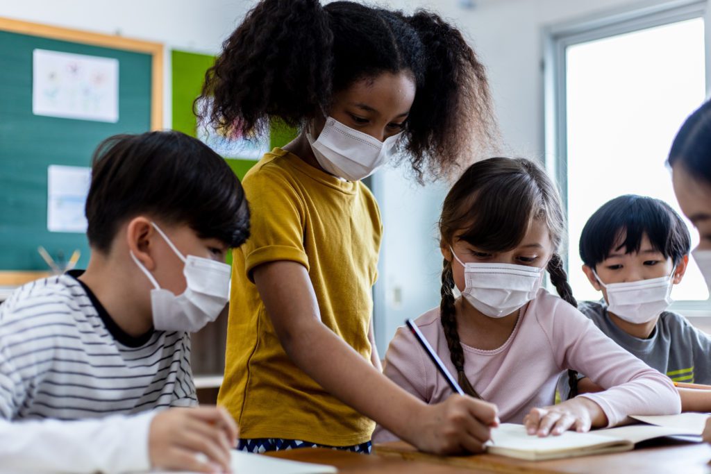 A Group Of Children Students Wearing Medical Masks In Classroom