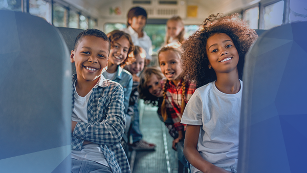 kids riding school bus smiling