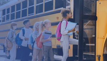 school kids with backpacks and binders lined up and boarding a yellow school bus