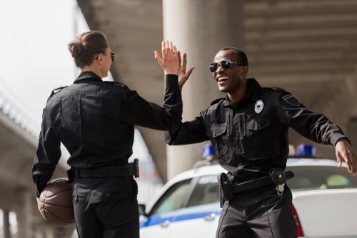 Police Officers With Basketball Ball Giving High Five