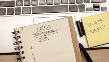 notebook with crisis management plan written on it