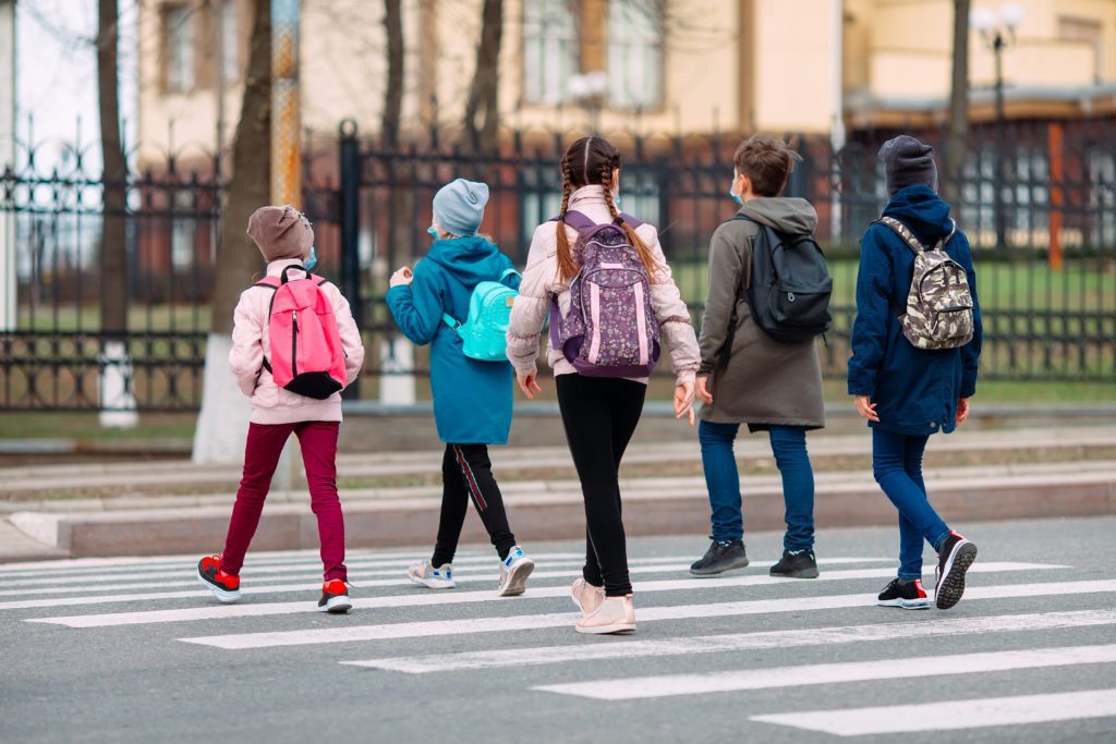 young students walking on a crosswalk