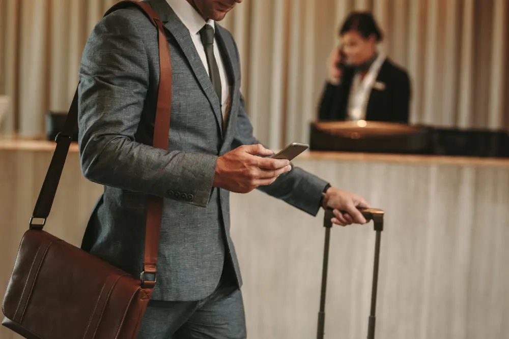hotel guest walking away from check in counter looking at phone